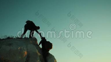 两个男子协同游<strong>客</strong>爬上一座山。 <strong>徒步</strong>旅行者<strong>徒步</strong>旅行冒险登山日落攀登